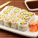 A white rectangular platter with California sushi rolls on it.