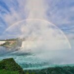 A full rainbow forming over Niagara Falls, from the horseshoe to the American side of the falls.