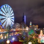The Christmas market in Edinburgh, at night, with a ferris wheel on the left.