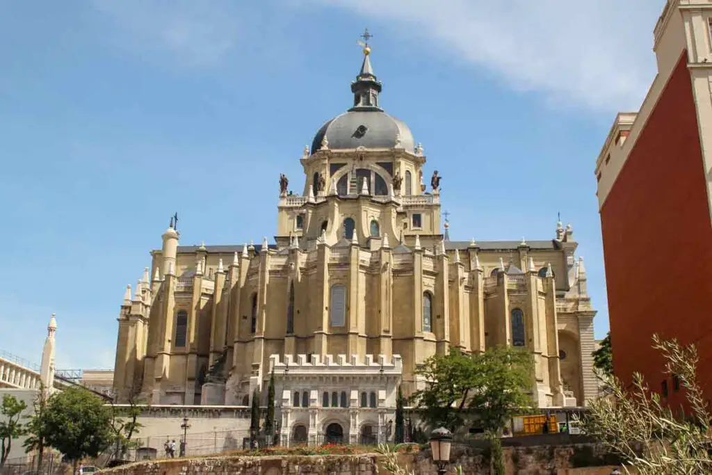 A view of the Cathedral from below the hill it is built on. It is a very large building, with a round cupola. The sky above it blue, without any clouds.