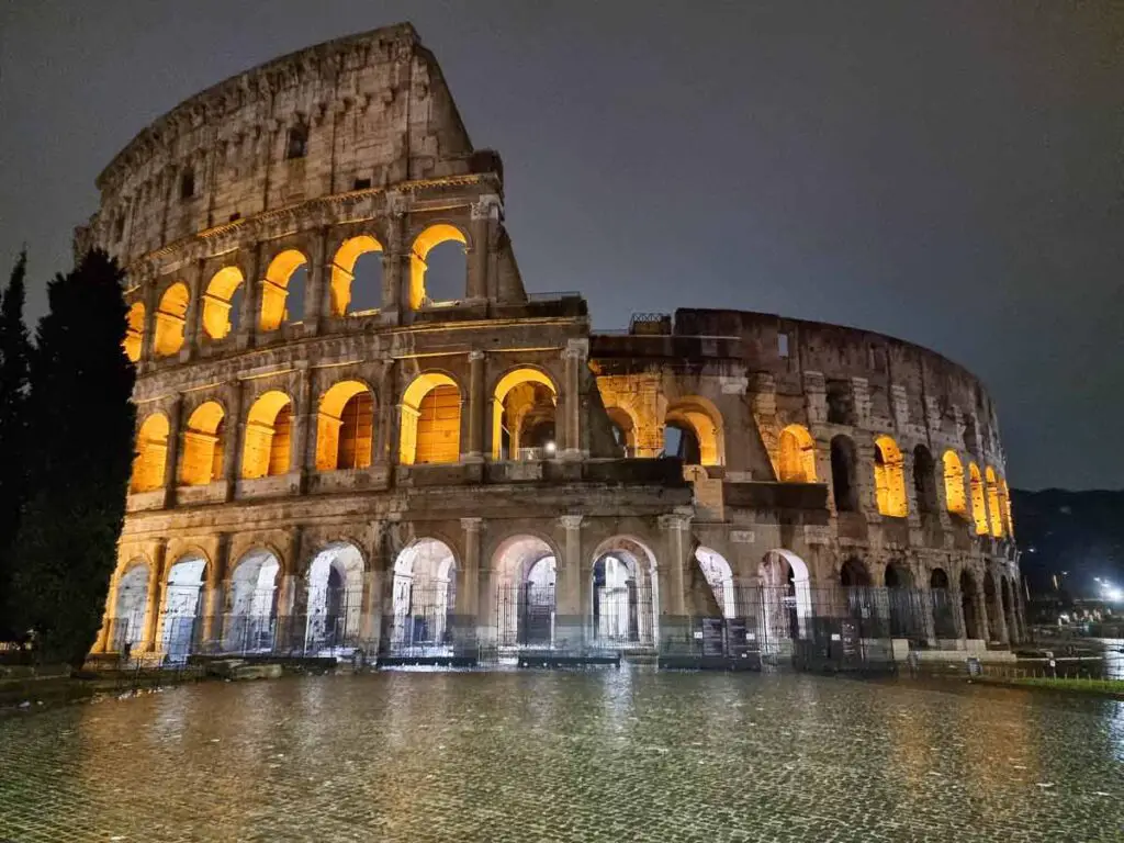 A photo of the Colosseum in Rome all lit up, at night.