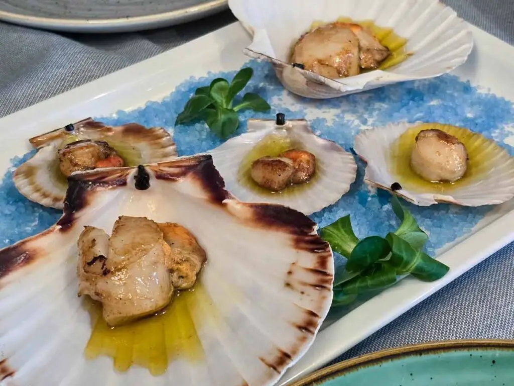 A platter with scallops served in their own shells