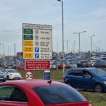 A photo of the land car park in Luton airport, with the fees associated with it. The car park is full of cars.