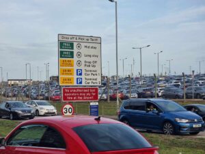 A photo of the land car park in Luton airport, with the fees associated with it. The car park is full of cars.