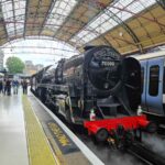 70000 Britannia locomotive in Victoria station on platform 2, with white steam underneath it