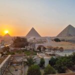 The pyramids at sunset. The sun is behind the top of the third pyramid, on the left of the photo.
