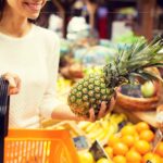Swipe Right on Aisle 5: How A Supermarket Became Spain's Hottest Dating App A woman holding a large pineapple in one hand and an orange shopping basket in the other.