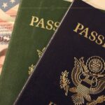 A close-up of two passport next to each other, one blue and one green.