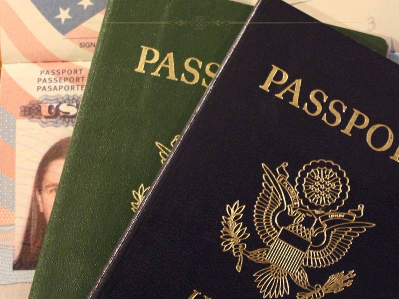 A close-up of two passport next to each other, one blue and one green.