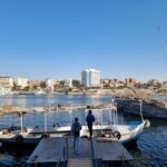 Two men walking towards a public transport ferry in Aswan.