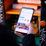 A close-up of a hand holding a phone with Instagram open on it.