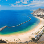 A photo of a bay and a large sandy beach on a sunny day.