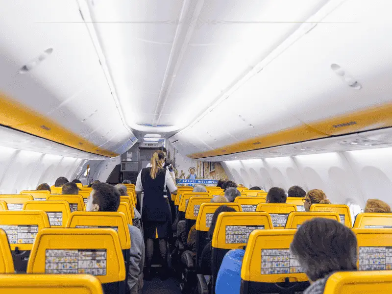 The interior of a plane with yellow chairs