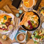 A wooden table with a large breakfast spread