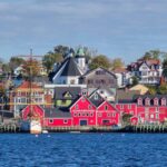 The waterfront of Lunenburg seen from across the harbour, on a relatively clear day. The houses are all colourful.