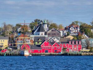 The waterfront of Lunenburg seen from across the harbour, on a relatively clear day. The houses are all colourful.