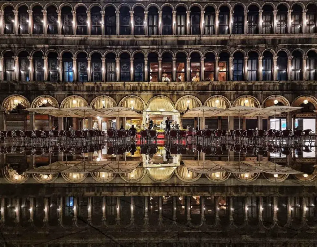 The columns in Piazza San Marco reflecting in the water below, at night, creating a mirror on the floor.