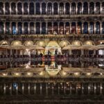 The columns in Piazza San Marco reflecting in the water below, at night, creating a mirror on the floor.
