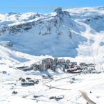 A very small resort surrounded by tall mountains and a lot of snow