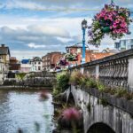 These Solid Countries Offer Americans an Easy Path to A Second Passport A picturesque city in Ireland, on the shore of a river, crossed by a stone bridge.