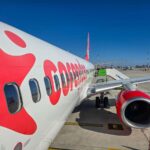 A photo of the white plane with Corendon written on it in red letters