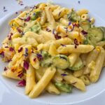What to Eat in Pisa For a Memorable Foodie Experience – Traditional Pisan Dishes A plate of pene pasta with courgettes and prawns, topped with edible flowers
