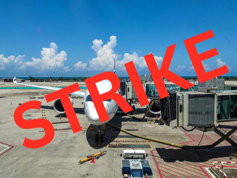 A photo of a plane at the airport with red letters spelling "strike" on top
