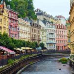 Everything You Need to Know About Planning a Czech Republic Road Trip Pastel coloured buildings on the side of a river, in Karlovy Vary
