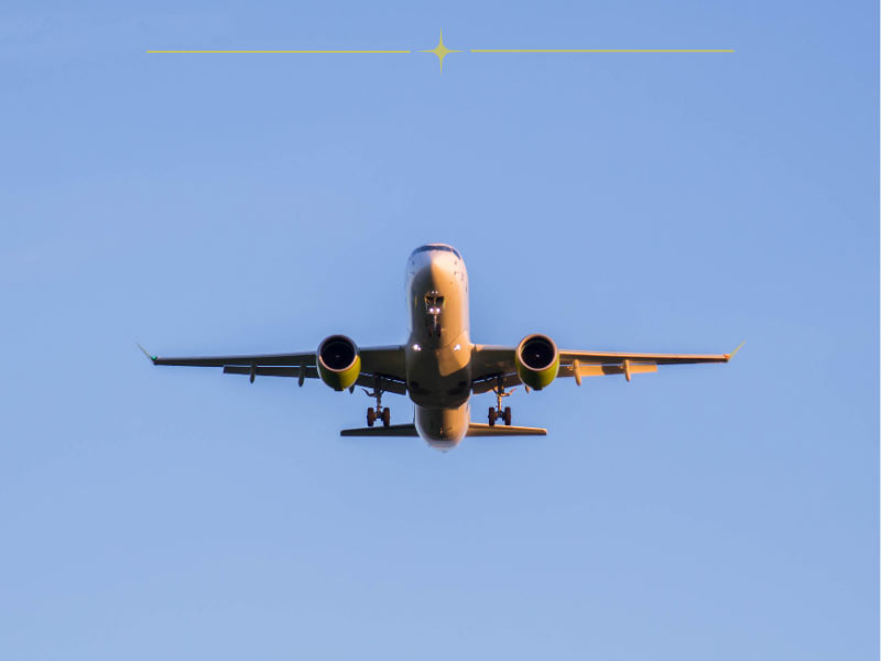 A yellow plane taking off on a blue sky